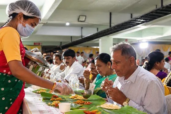 Rice being served onto banana leaves.